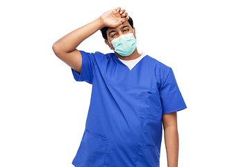 Image showing tired indian male doctor in blue uniform and mask