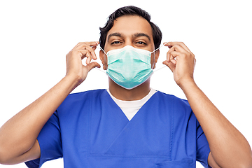 Image showing indian male doctor in blue uniform putting mask on