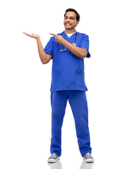 Image showing happy indian male doctor holding something on hand