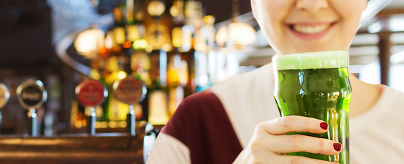 Image showing close up of woman with green beer in glass