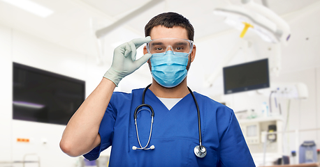 Image showing male doctor in goggles, mask and gloves