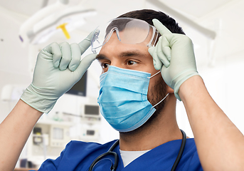 Image showing male doctor in goggles, mask and gloves