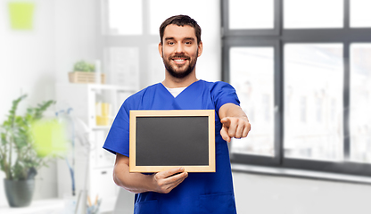 Image showing happy smiling male doctor or nurse with chalkboard