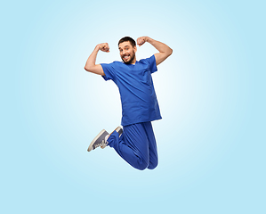 Image showing happy smiling doctor or male nurse jumping in air