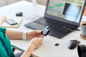 Image showing woman with sd card reader and laptop at office