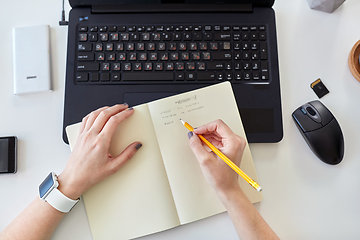 Image showing woman writing working plan to notebook at office