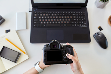 Image showing woman with camera and on laptop at office