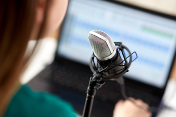 Image showing woman with microphone recording podcast at studio