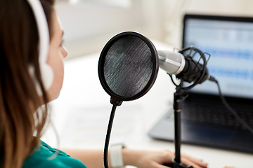 Image showing woman with microphone recording podcast at studio