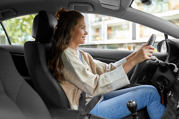 Image showing smiling woman or female driver driving car in city