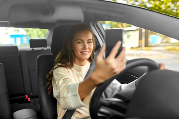Image showing woman or driver driving car and taking selfie