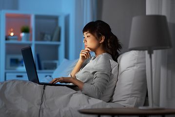 Image showing woman with laptop in bed at home at night