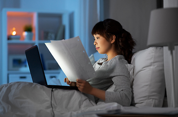 Image showing woman with laptop working in bed at night