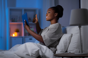 Image showing woman with tablet pc having video call in bed