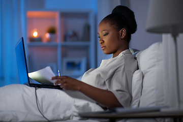 Image showing woman with laptop working in bed at night