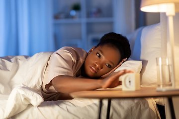 Image showing woman awaking because of alarm clock at night