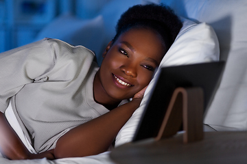 Image showing woman with tablet pc in bed at home at night