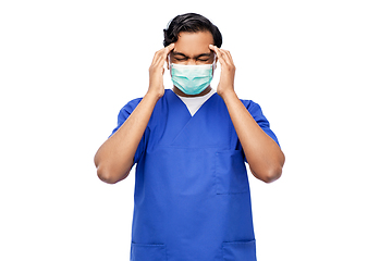 Image showing stressed indian doctor in mask having headache