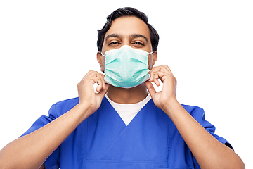 Image showing indian male doctor in blue uniform putting mask on