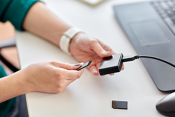 Image showing woman with sd card reader and laptop at office