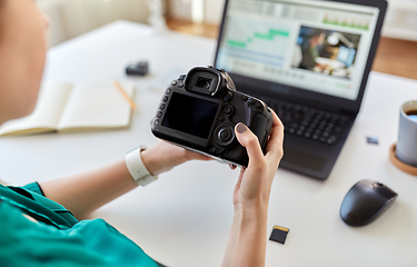 Image showing woman with camera and video editor on laptop