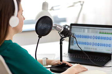 Image showing woman with microphone recording podcast at studio