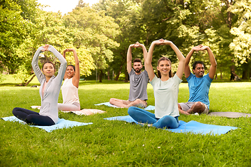 Image showing group of happy people doing yoga at summer park