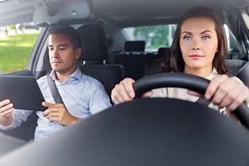 Image showing woman and driving school instructor in car