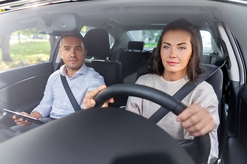 Image showing woman and driving school instructor in car