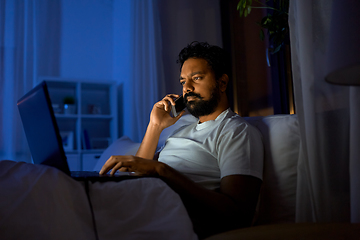 Image showing indian man with laptop calling on phone at night