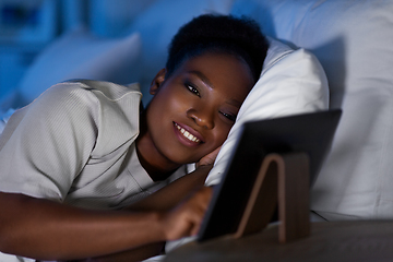 Image showing woman with tablet pc in bed at home at night