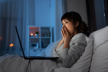 Image showing stressed woman with laptop working in bed at night