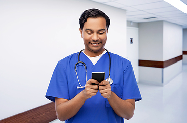 Image showing smiling doctor or male nurse using smartphone