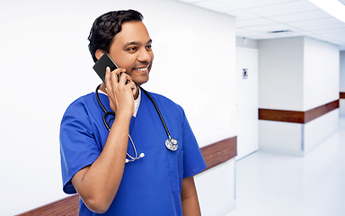 Image showing smiling doctor or male nurse calling on smartphone