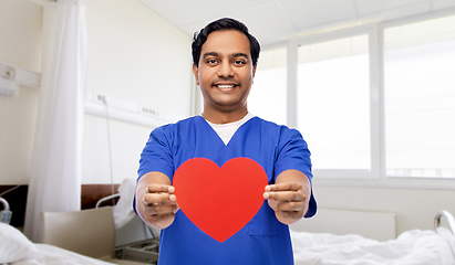 Image showing smiling male doctor with red heart on clipboard