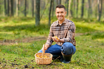 Image showing happy man with basket picking mushrooms in forest