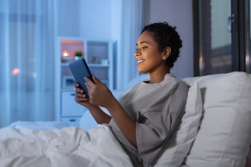 Image showing woman with tablet pc in bed at home at night