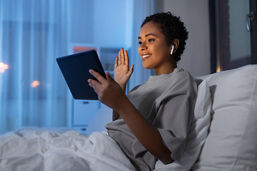 Image showing woman with tablet pc in bed having video call