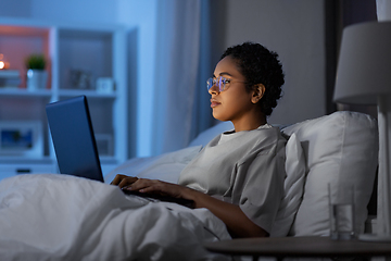 Image showing woman with laptop in bed at home at night