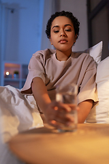 Image showing african american woman drinking water at night