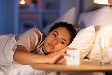 Image showing woman awaking because of alarm clock at night