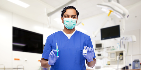 Image showing indian doctor in mask with syringe and medicine