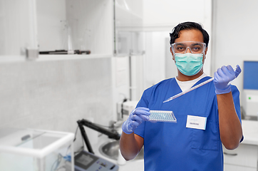 Image showing indian scientist in mask with dropper and vaccine