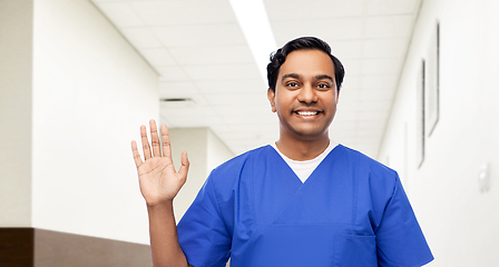 Image showing happy indian doctor or male nurse waving hand