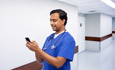 Image showing smiling doctor or male nurse using smartphone