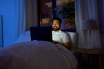 Image showing indian man with laptop in bed at home at night