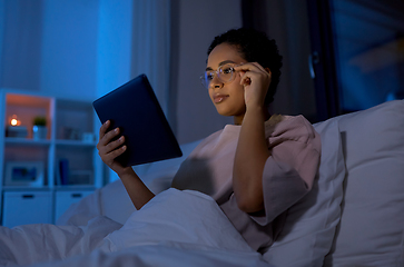 Image showing woman with tablet pc in bed at home at night