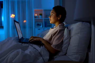 Image showing woman with laptop in bed at home at night