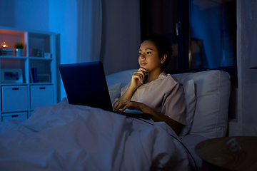 Image showing woman with laptop in bed at home at night