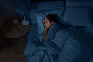 Image showing african woman sleeping in bed at home at night